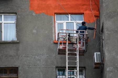 Worker paints the wall of a residential house